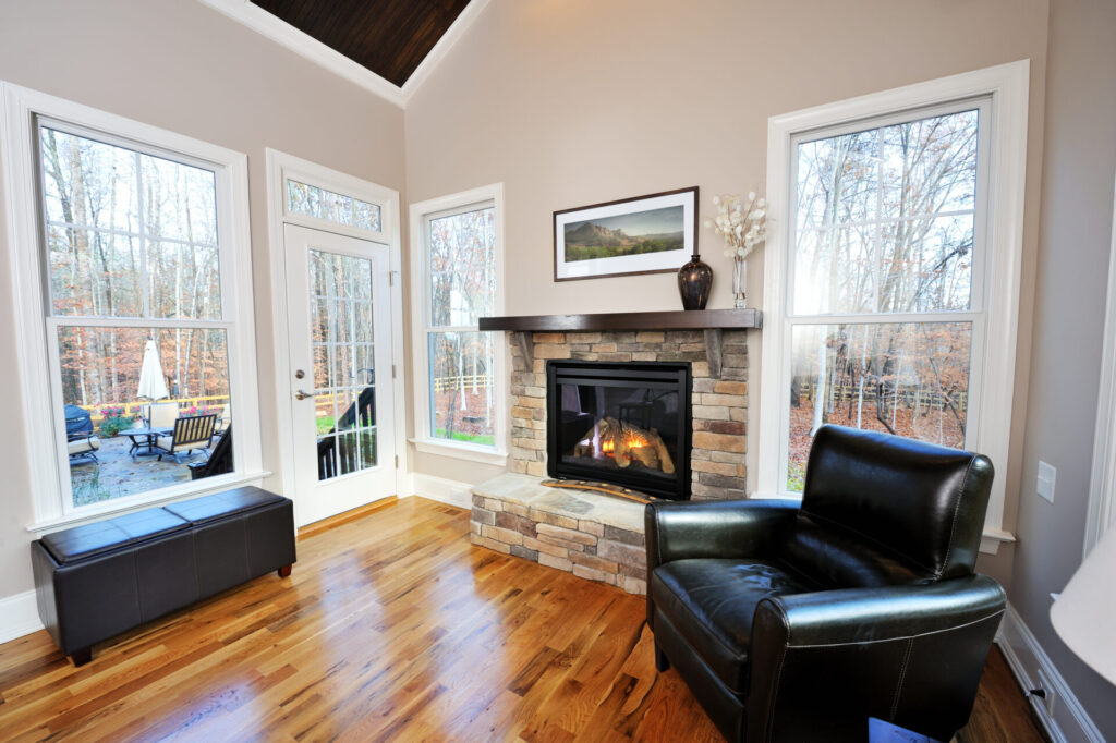 Living room with fireplace, hardwood floors, and black seat